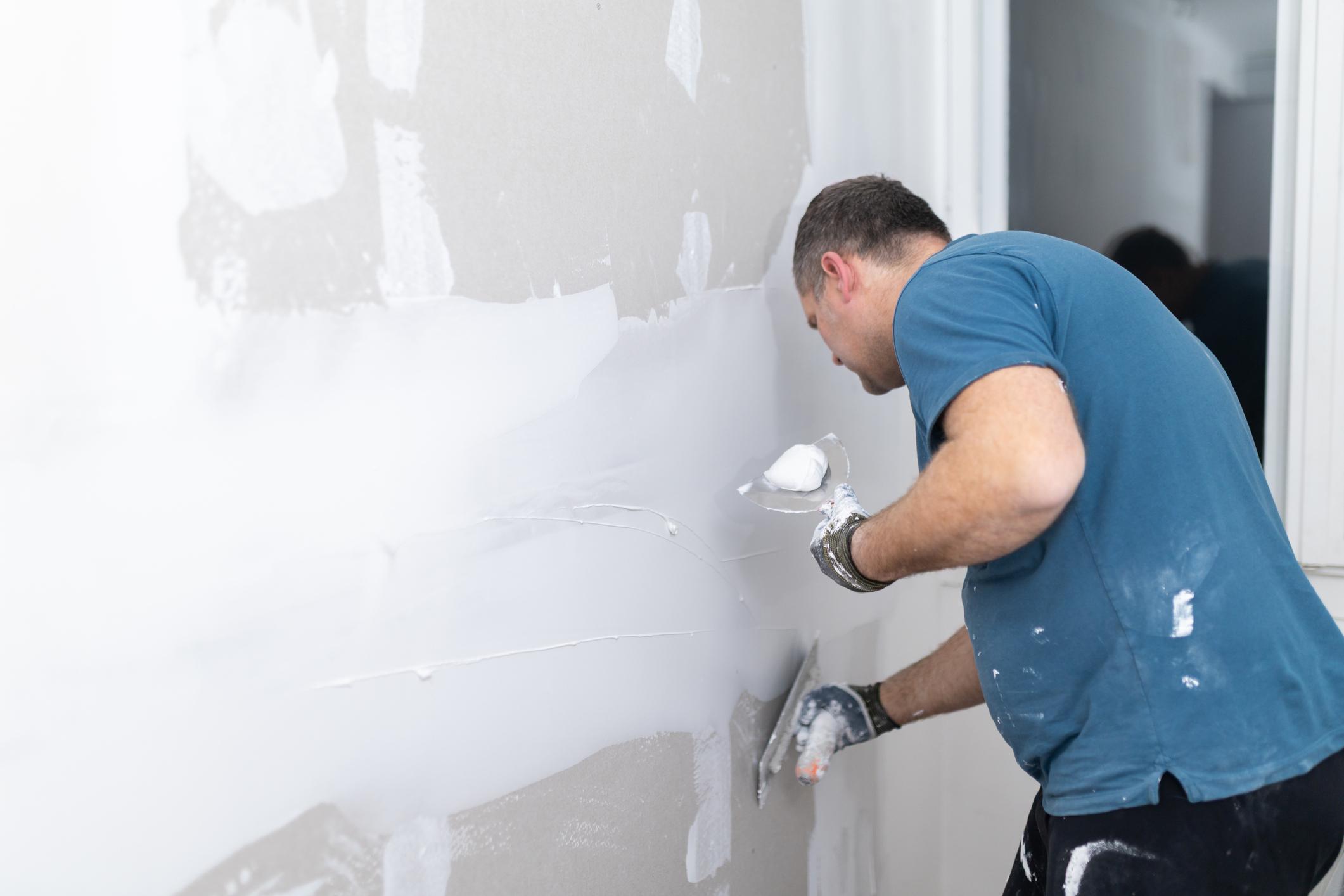 Applying joint compound to drywall hole repair in Calgary