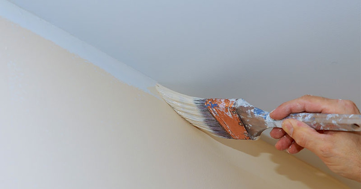 Applying paint roller on interior wall Calgary